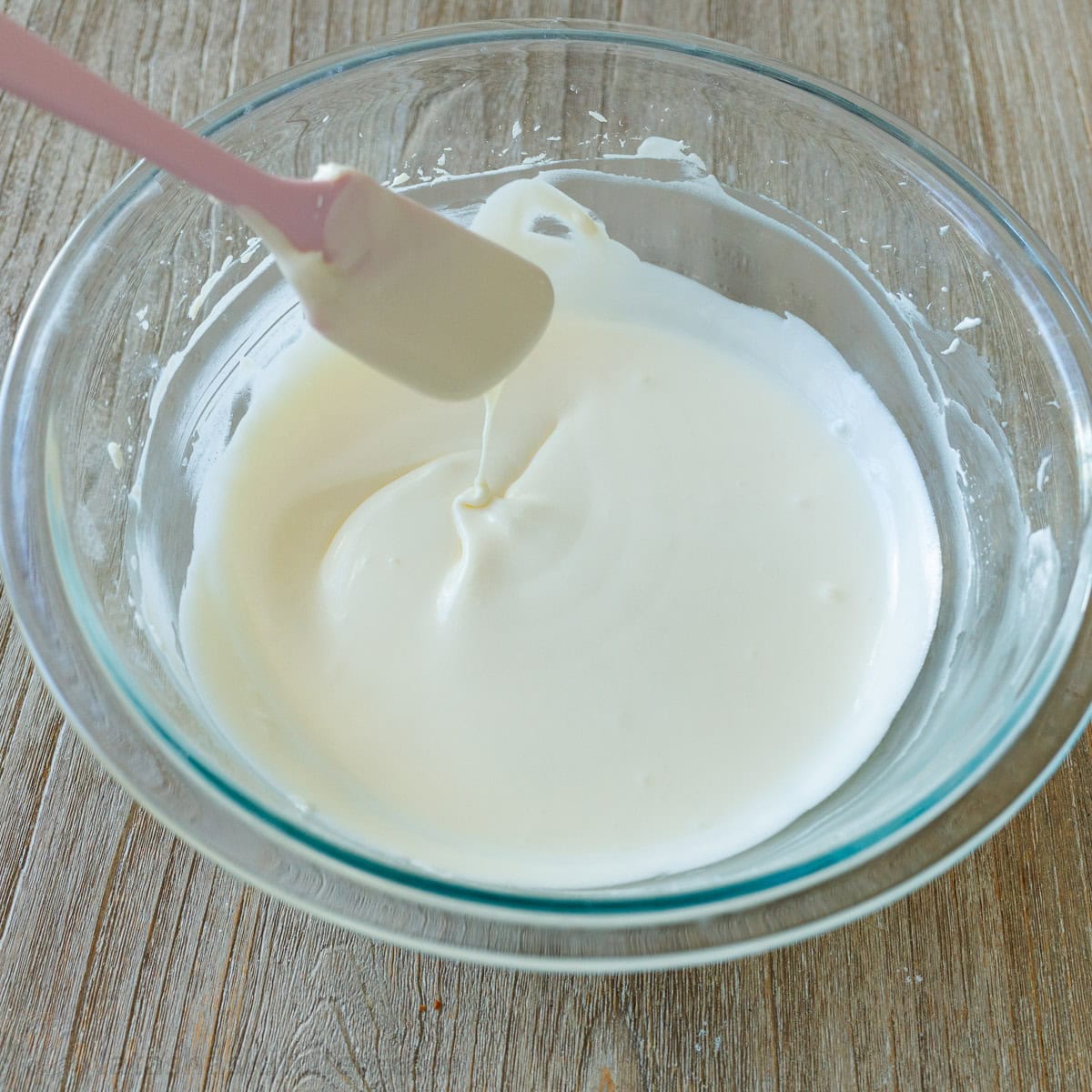 A spatula dipped into Cream cheese glaze for cake