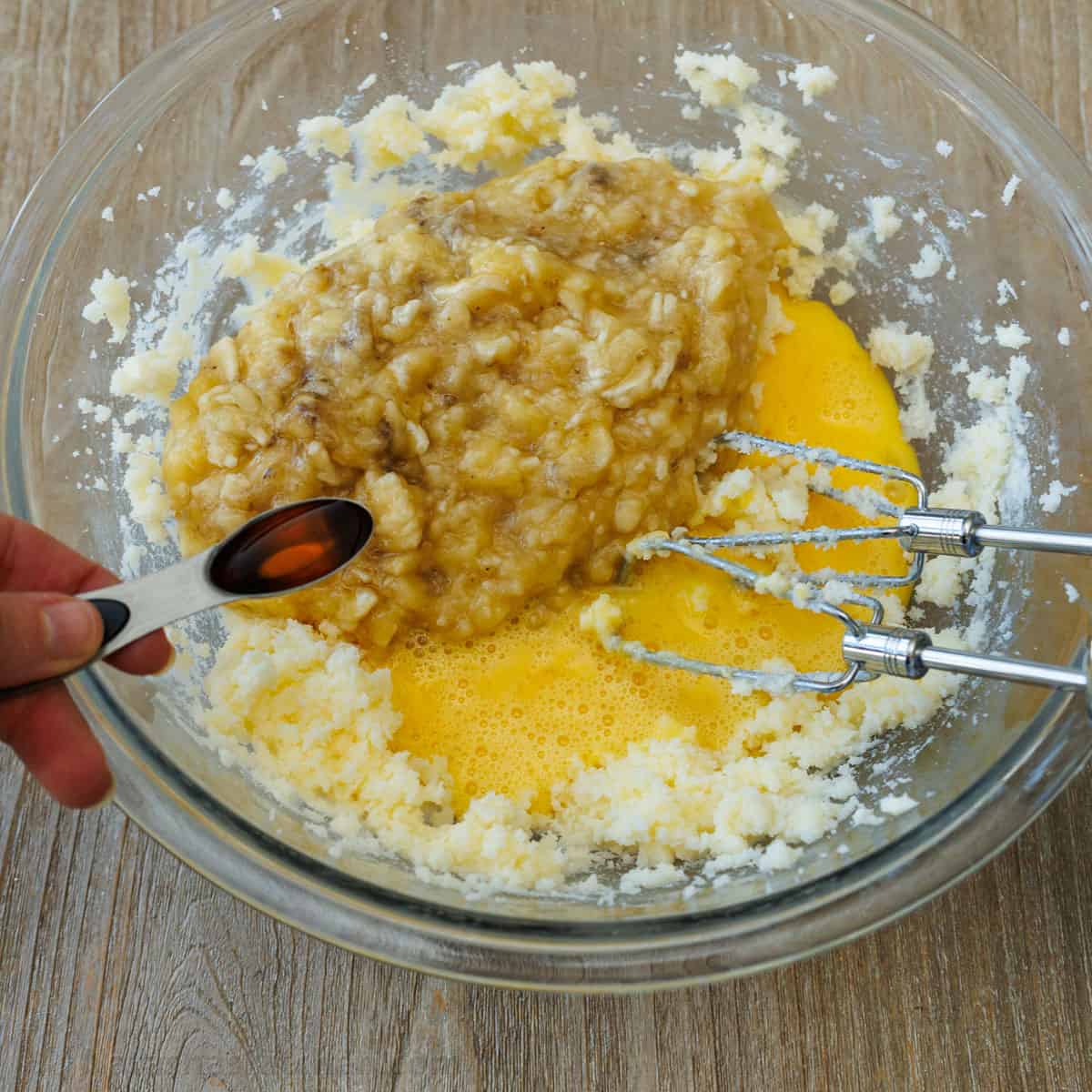 Adding banana, eggs and vanilla to creamed butter