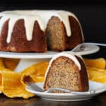 A slice of Banana Bundt Cake with Cream Cheese Glaze with the full cake in the background