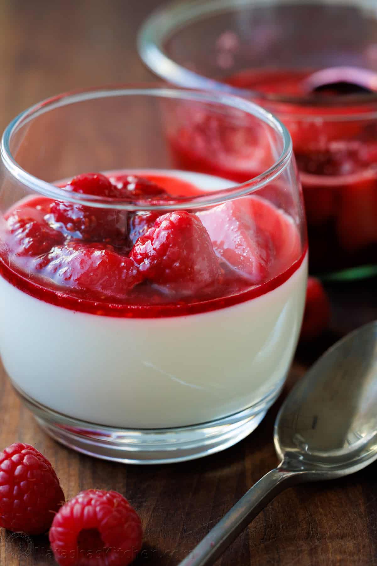 Panna Cotta served in a glass with fresh berry sauce on top