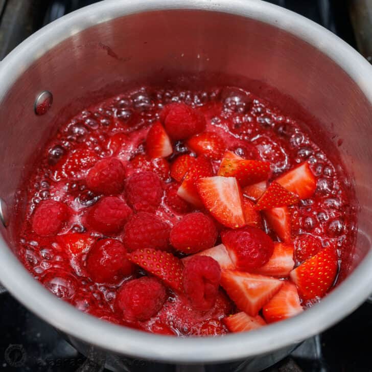 Mixing fresh berries into sauce