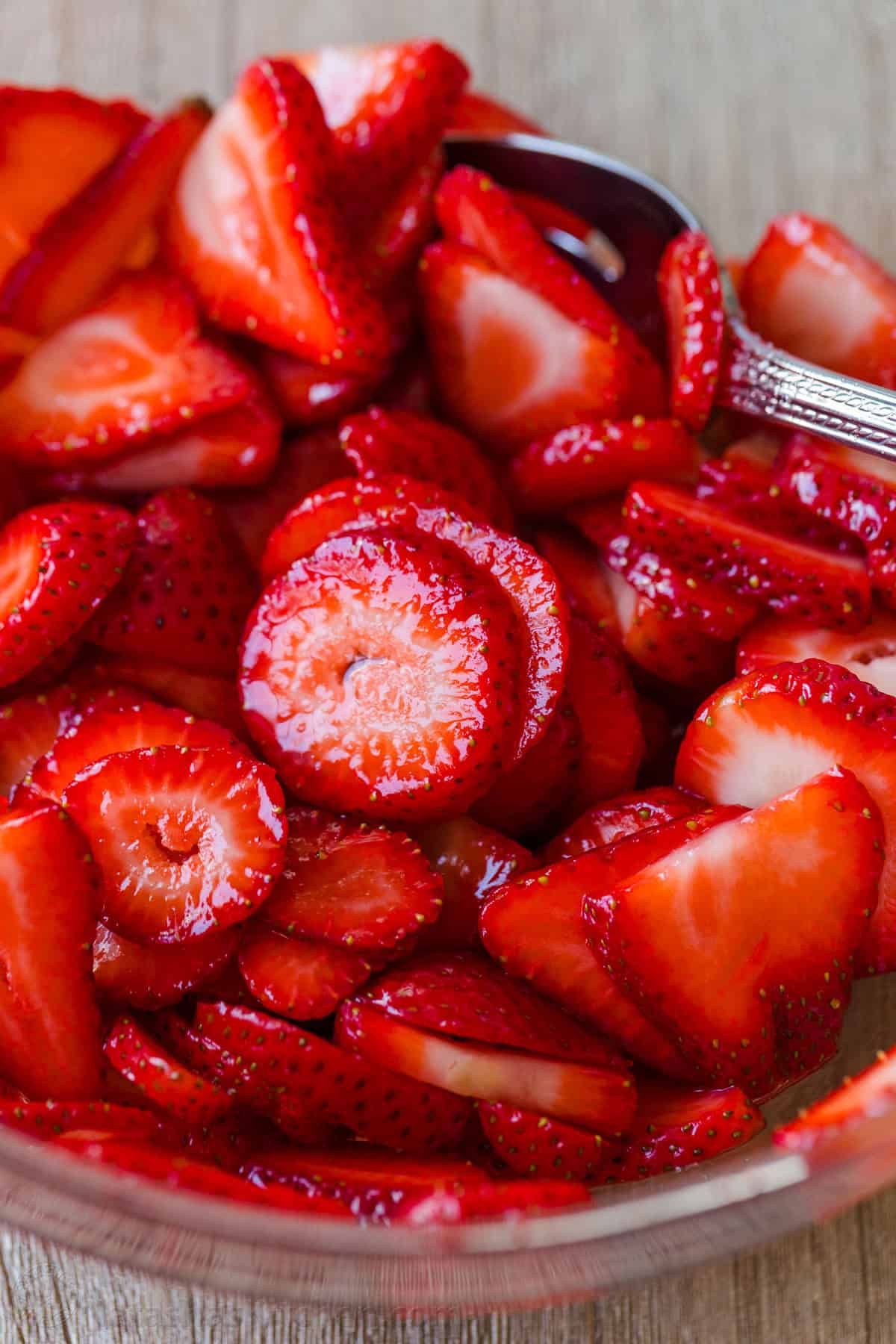 strawberries and sugar mixed into a bowl to top strawberry shortcake