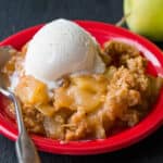 Apple Crisp served on a red plate with ice cream