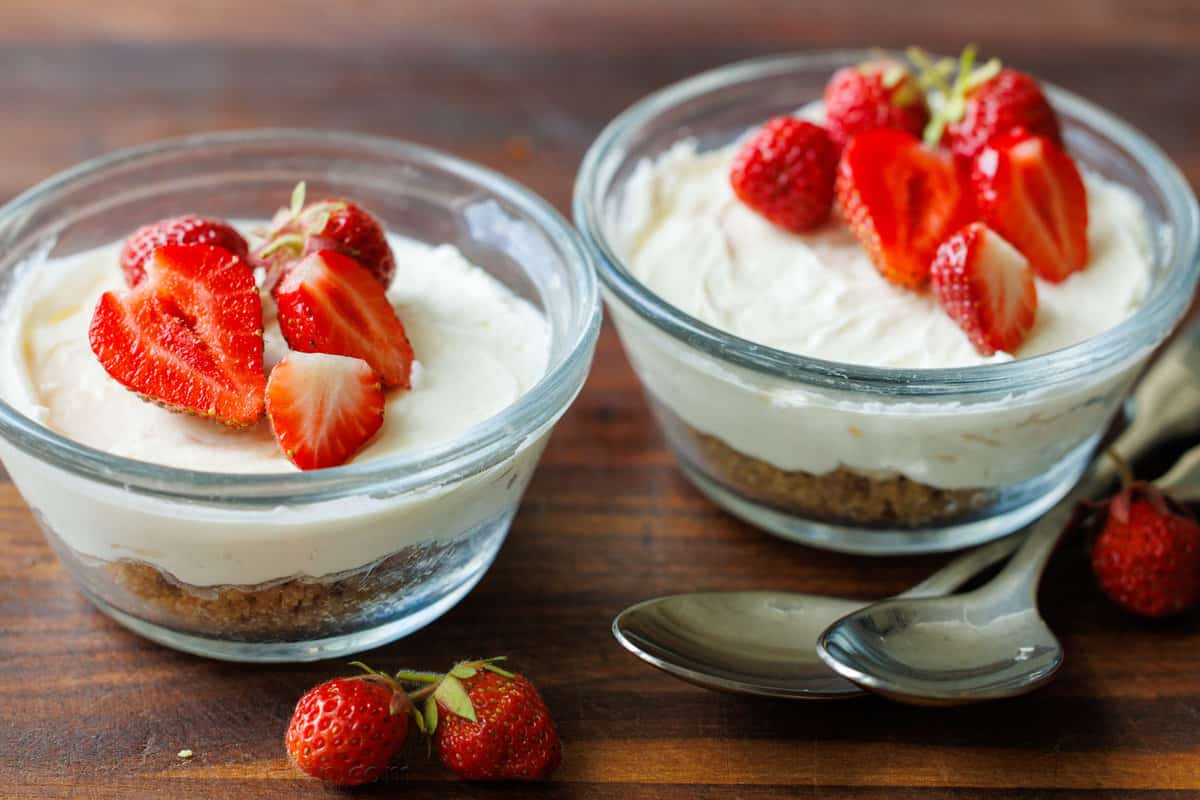 no bake mini cheesecakes prepared in glass ramekins with strawberry topping